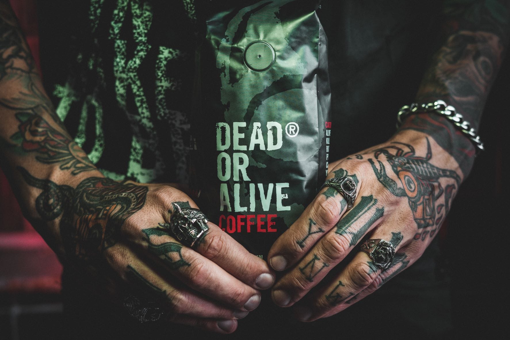 tattoowierte händle halten eine dead or alive coffee packung