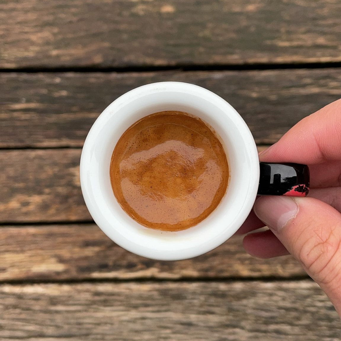 Espresso mit dichter Crema in einer weißen DEAD OR ALIVE COFFEE Tasse