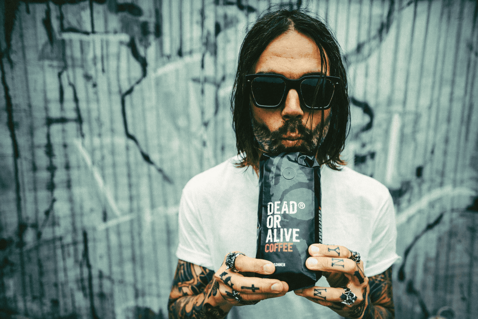 ben mit original kaffee vor blechwand mit graffitti